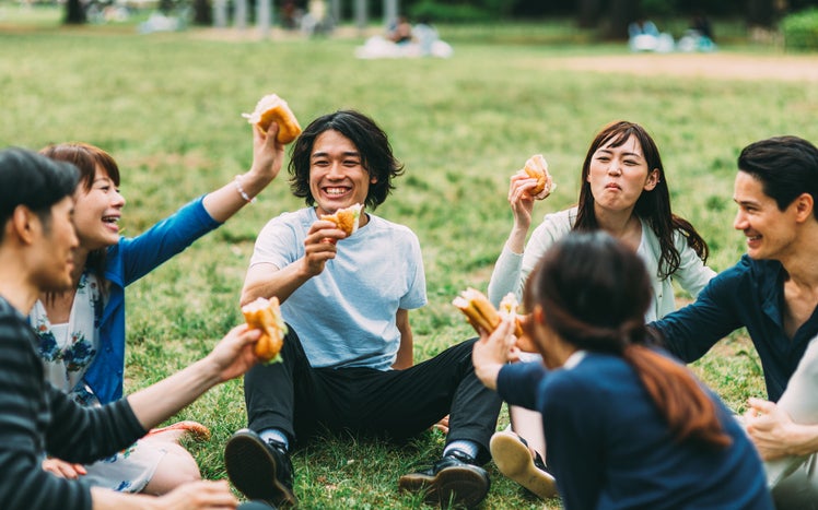 Grupo de amigos comiendo snacks para picnic