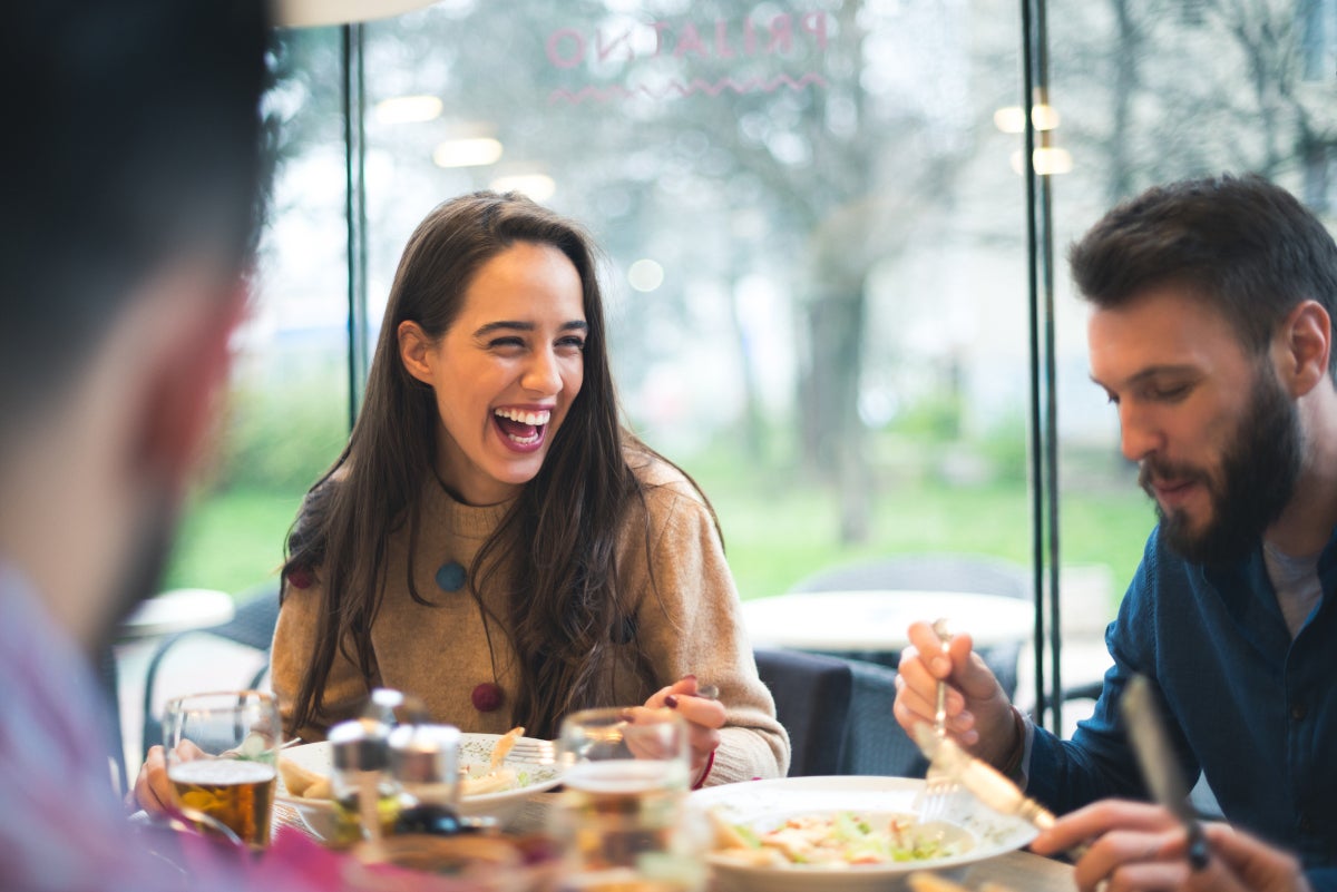 Amigos sonriendo mientras comparten pasabocas para fiestas