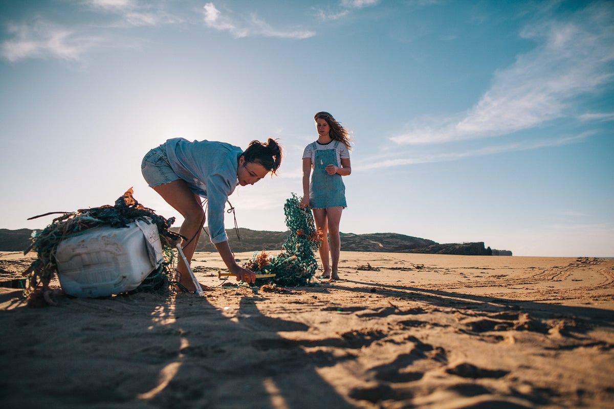 Dos mujeres recogiendo basura en la playa