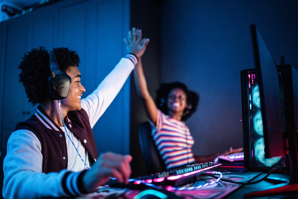 Jóvenes jugando videojuegos y celebrando que pasaron el nivel
