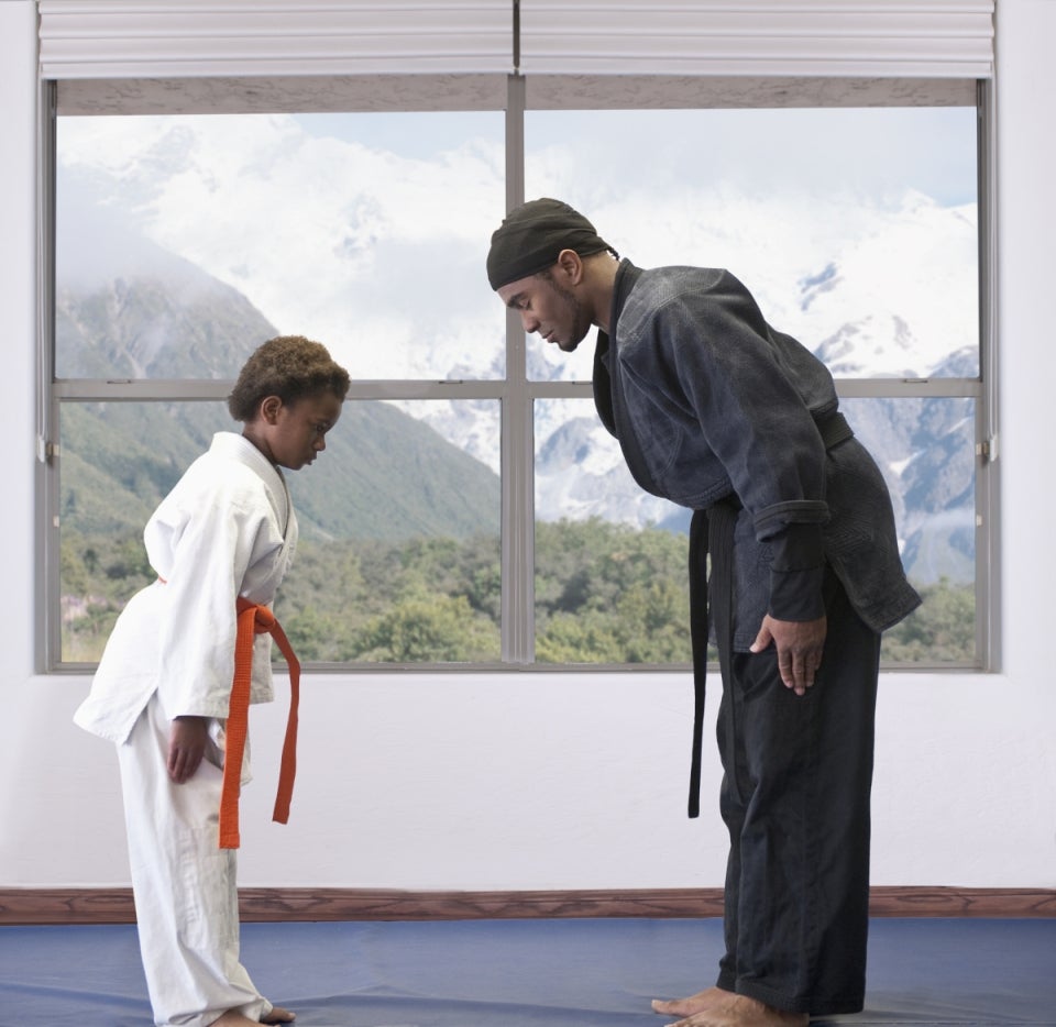 Alumno y profesor de deporte de combate haciendo un saludo