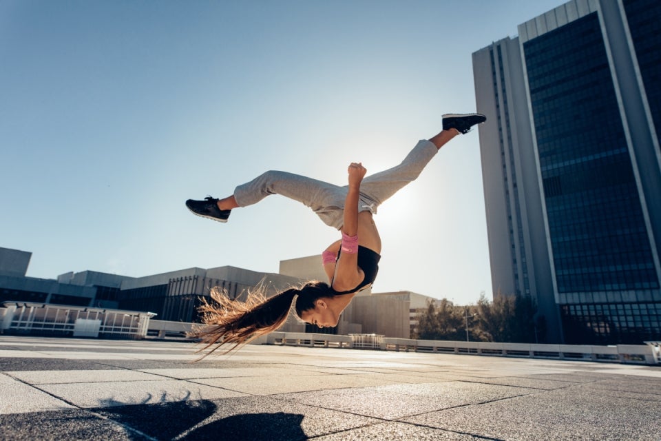 Mujer practicando parkour en la calle