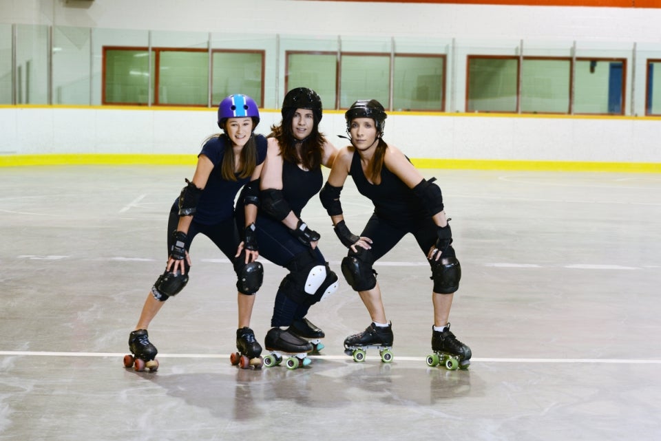 Tres mujeres que practican Roller Derby con su equipamiento