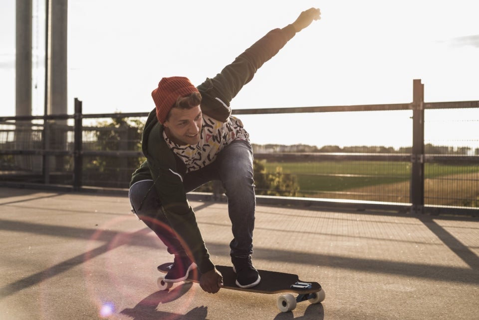 Hombre haciendo trucos en su patineta por la calle
