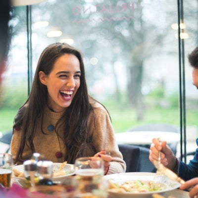 Amigos sonriendo mientras comparten pasabocas para fiestas