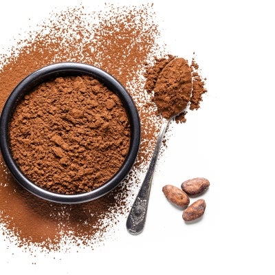 Cocoa en polvo en una taza al lado una cuchara