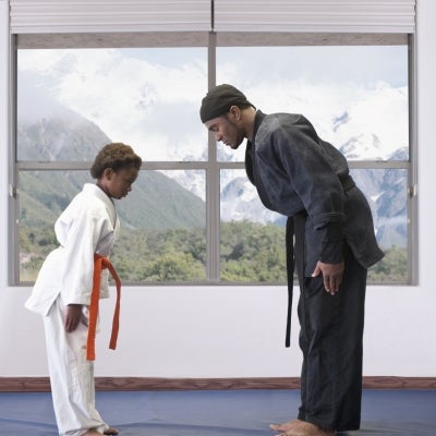 Alumno y profesor de deporte de combate haciendo un saludo