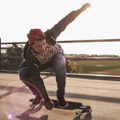 Hombre haciendo trucos en su patineta por la calle