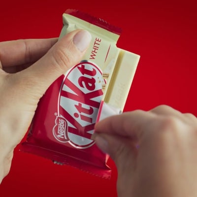 Manos abriendo una KITKAT® White